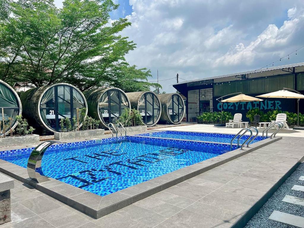 a large swimming pool in front of a building at Reserve The Cozytainer in Taiping