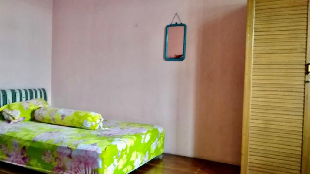 um quarto com um sofá verde e um espelho em Sewa Rumah 4 Kamar Tidur em Bandung