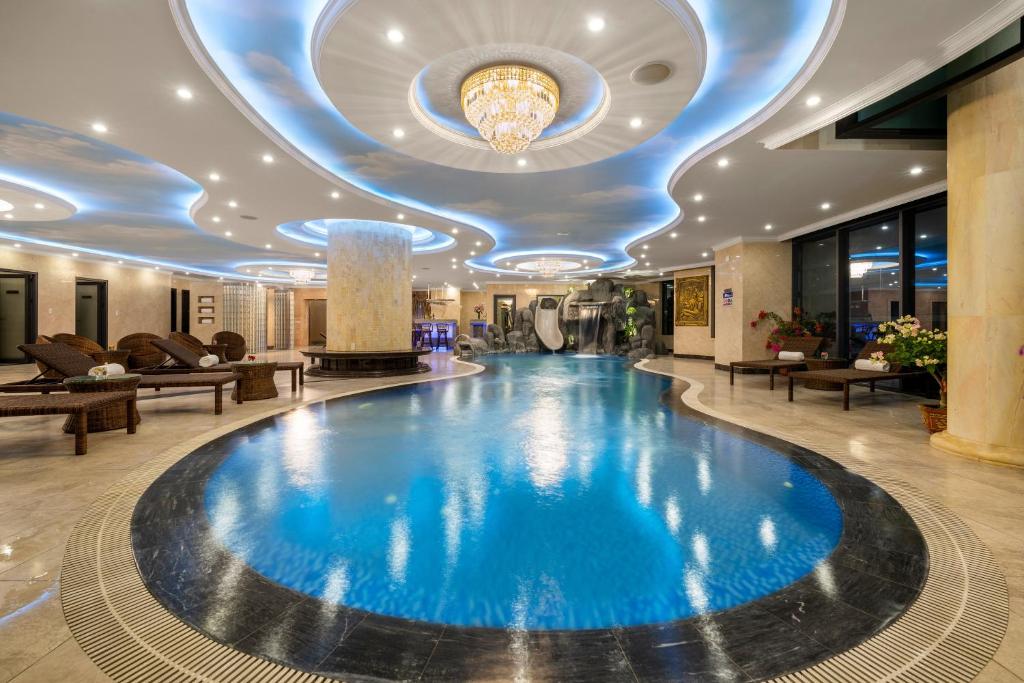 einen großen Pool in einer Hotellobby mit einer Decke in der Unterkunft V-Hotel in Đà Nẵng