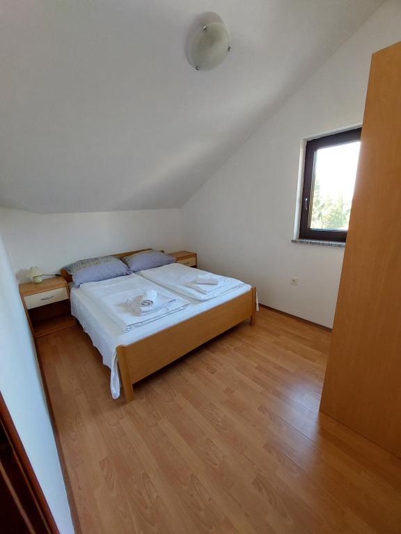 a bedroom with a bed and a window at Apartmani Romana in Punat