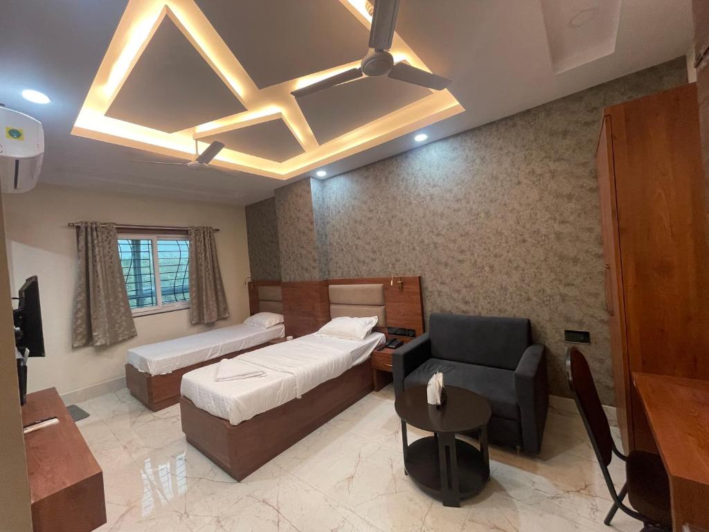 a bedroom with a bed and a couch and a chair at Hotel Dayaljeet in Jamshedpur