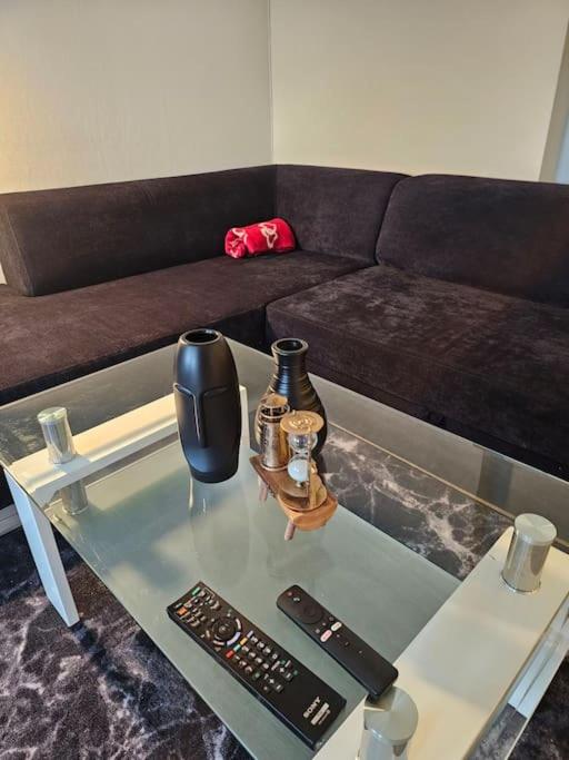 a living room with a couch and a glass table at skyline flat with free parking in Lorenskog