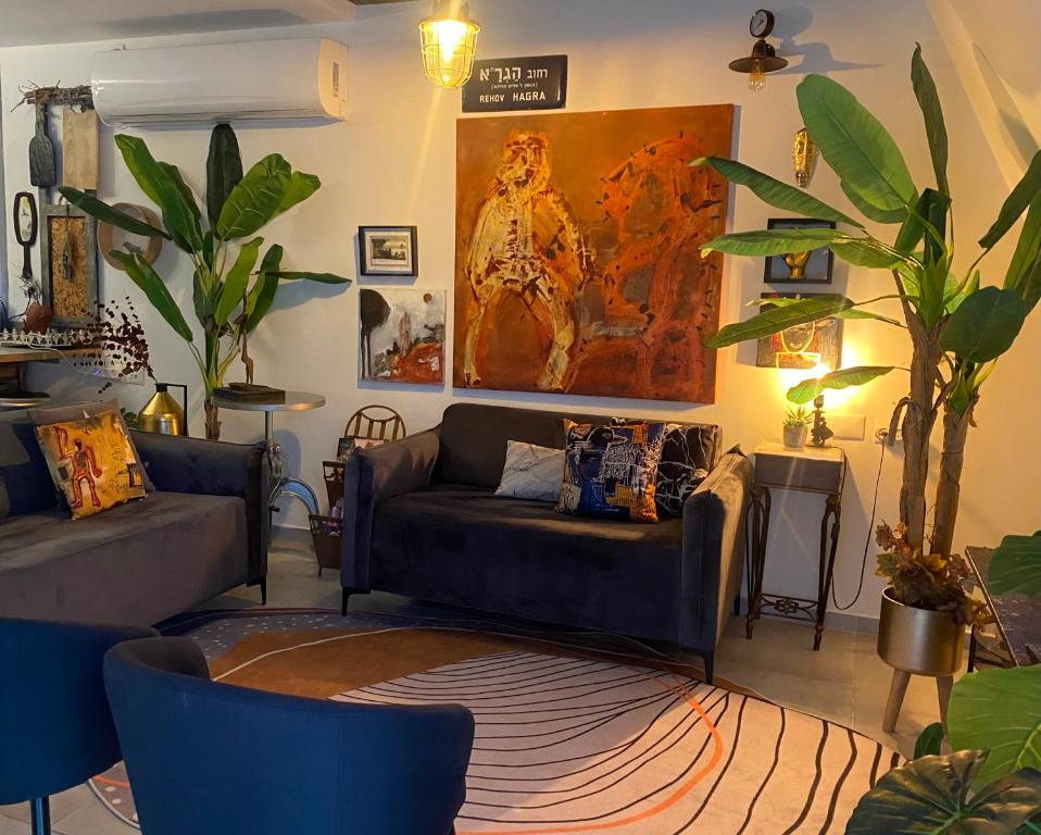 a living room with a couch and a painting on the wall at Inspirational Apartment in Tel Aviv