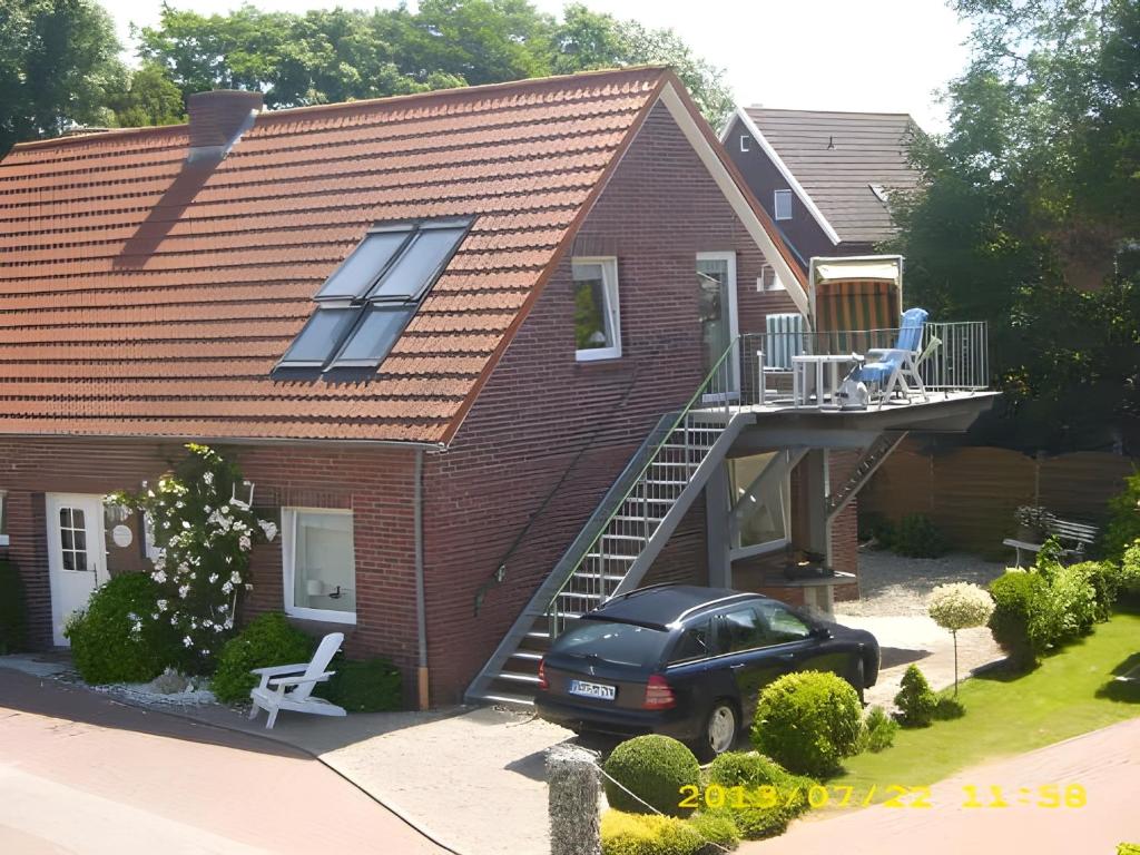 een huis met een auto ervoor geparkeerd bij Fennas Ferienwohnungen - Hanne in Dornumersiel