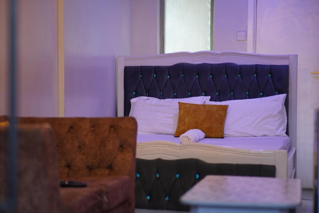 - un lit avec une tête de lit violette et un oreiller dans l'établissement Serenity Retreat, à Nairobi