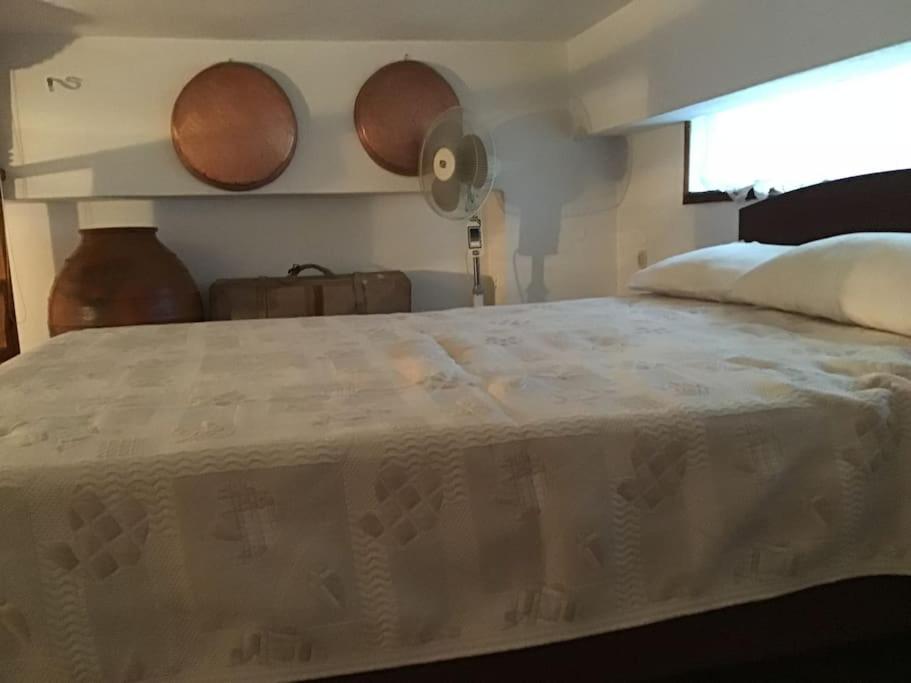 una camera da letto con un grande letto bianco con una finestra di Θέτιδα House a Skiros