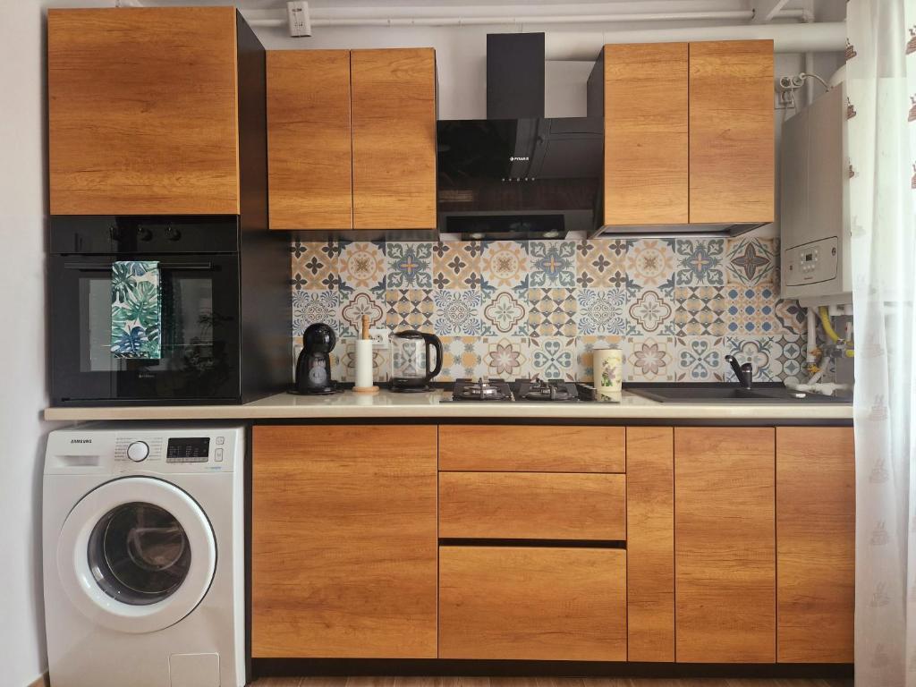 uma cozinha com uma máquina de lavar roupa e uma máquina de lavar roupa em House of flowers em Petroşani