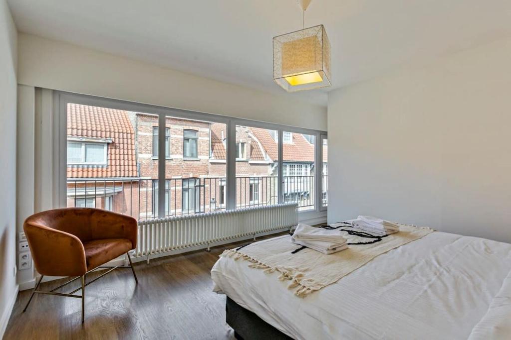 1 dormitorio con cama, silla y ventana grande en Anny's Home - Spacious holiday home in city center, en Brujas