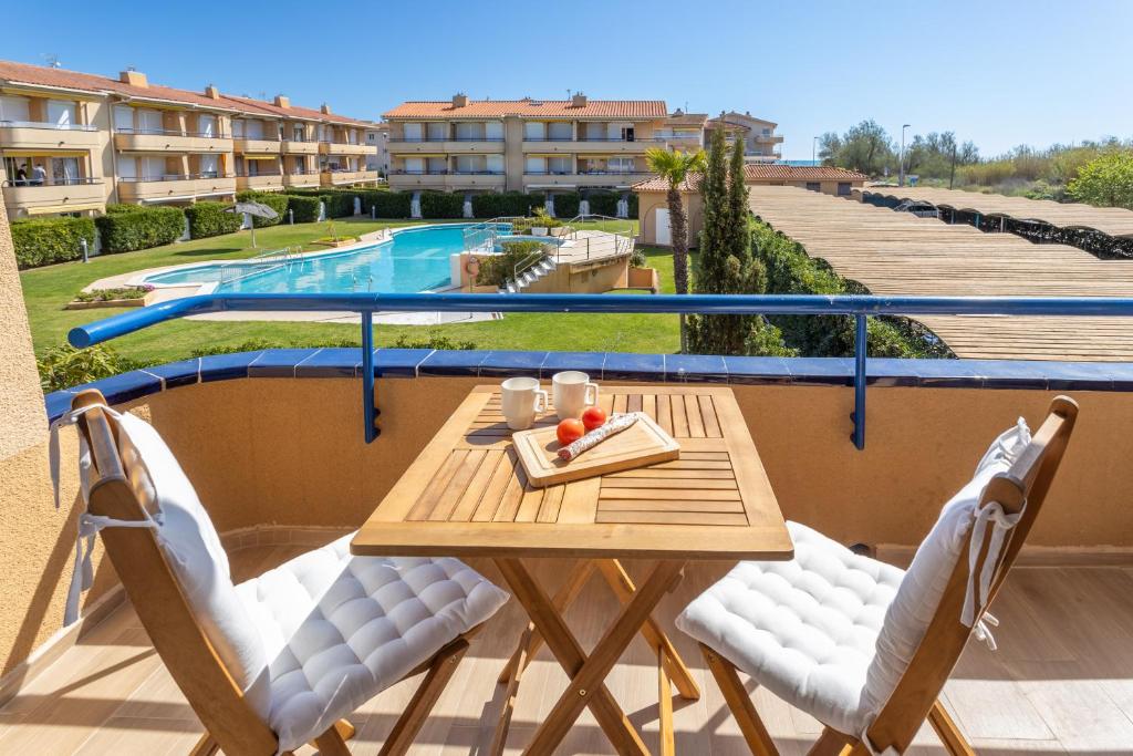a table and chairs on a balcony with a pool at Apartamento Tamarindos 500 in L'Estartit