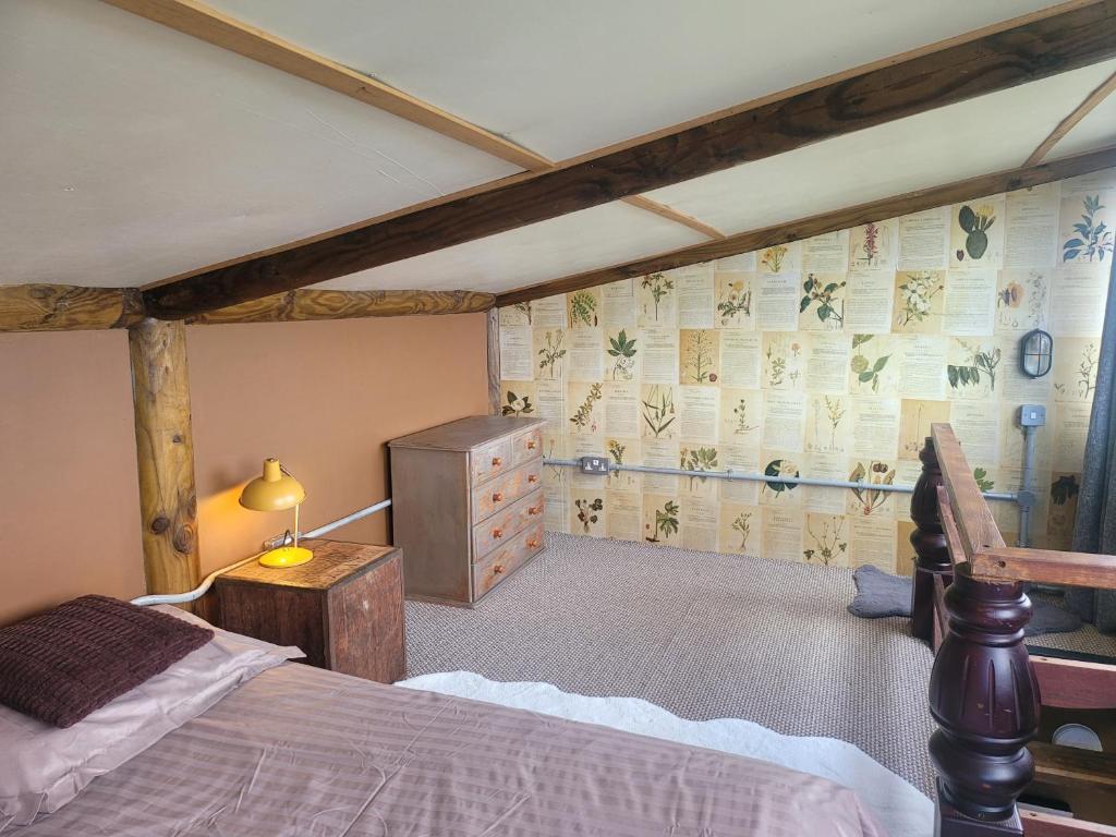 a bedroom with a bed and a dresser in a room at The Summerhouse in Llandegla