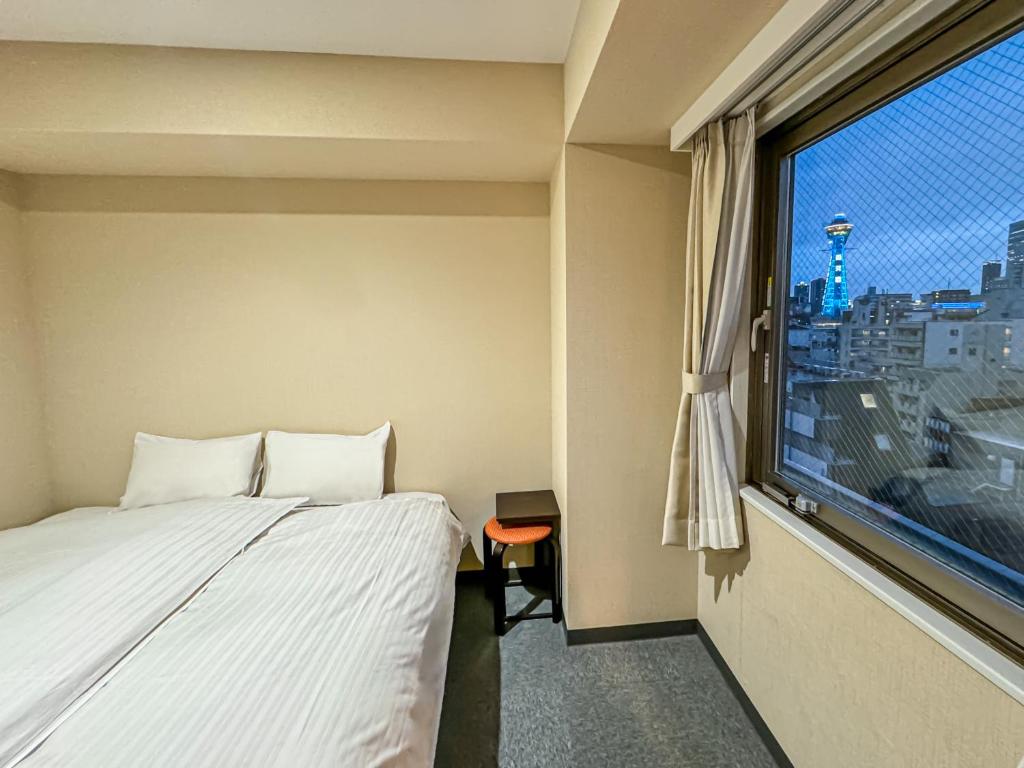Postel nebo postele na pokoji v ubytování CHECKinn Osaka Shinimamiya