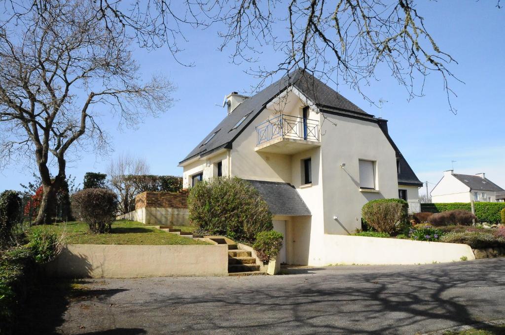 een wit huis met een balkon erop bij Entre ciel et mer - La maison de la pointe in Trégunc