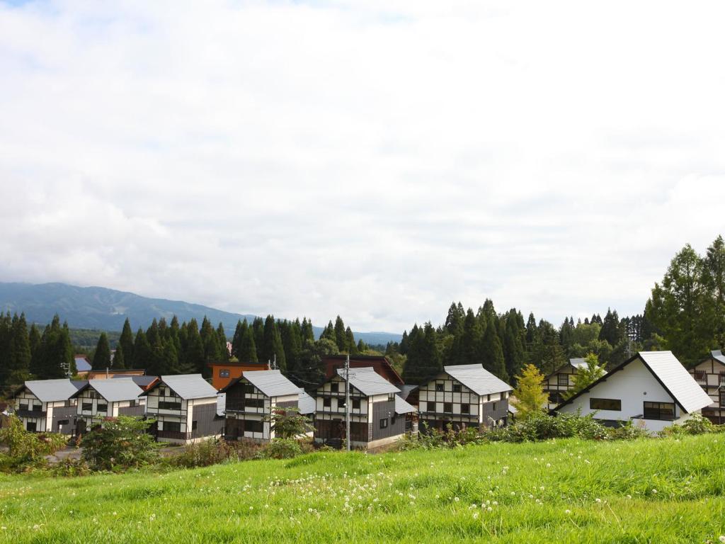 a group of houses on a hill in a field at Nagomiya Hirugano in Gujo