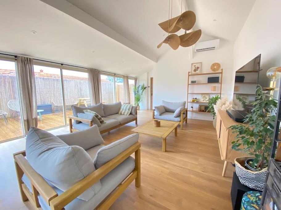 un salon avec un canapé et une table dans l'établissement Villa Genêts - 3 suites parentales avec terrasse et piscine - Proche plage, à Gujan-Mestras