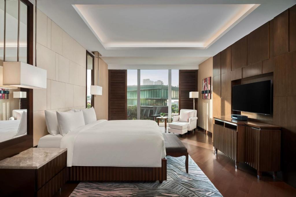 a hotel room with a bed and a television at JW Marriott Hotel Hanoi in Hanoi