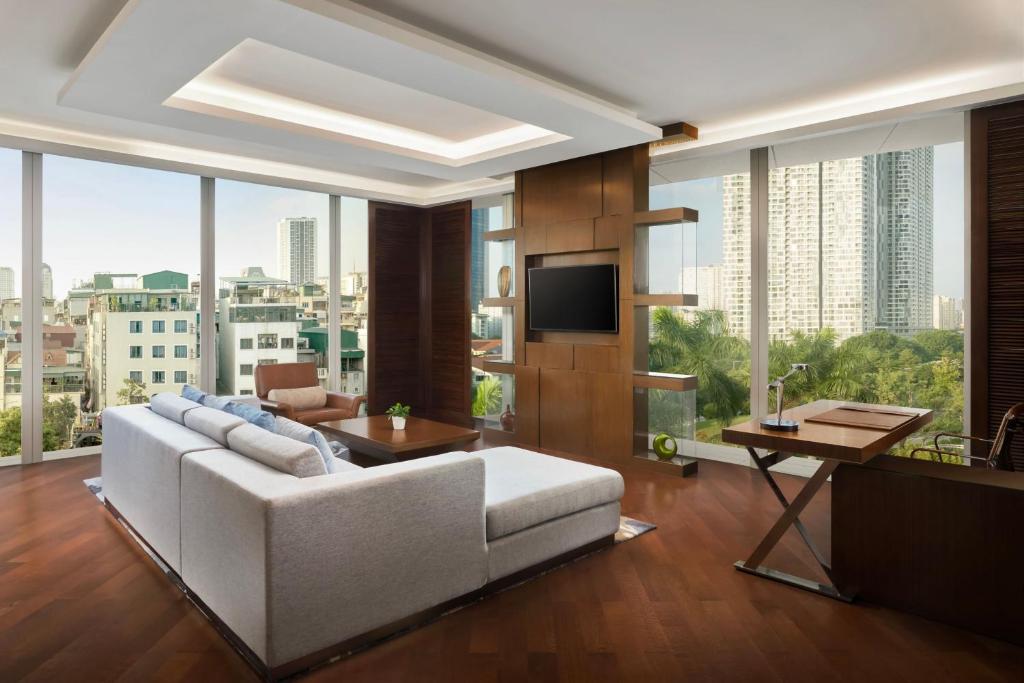 a living room with a white couch and a tv at JW Marriott Hotel Hanoi in Hanoi