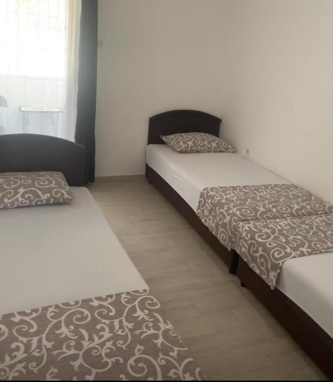 ein Zimmer mit 2 Betten und einem Sofa darin in der Unterkunft Nina in Šušanj