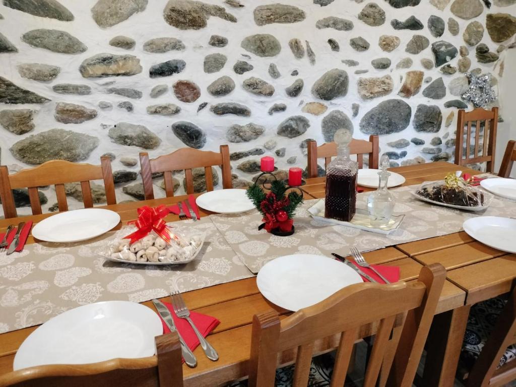 una mesa con platos blancos y arcos rojos en Casa de Piatra, en Porumbacu de Sus