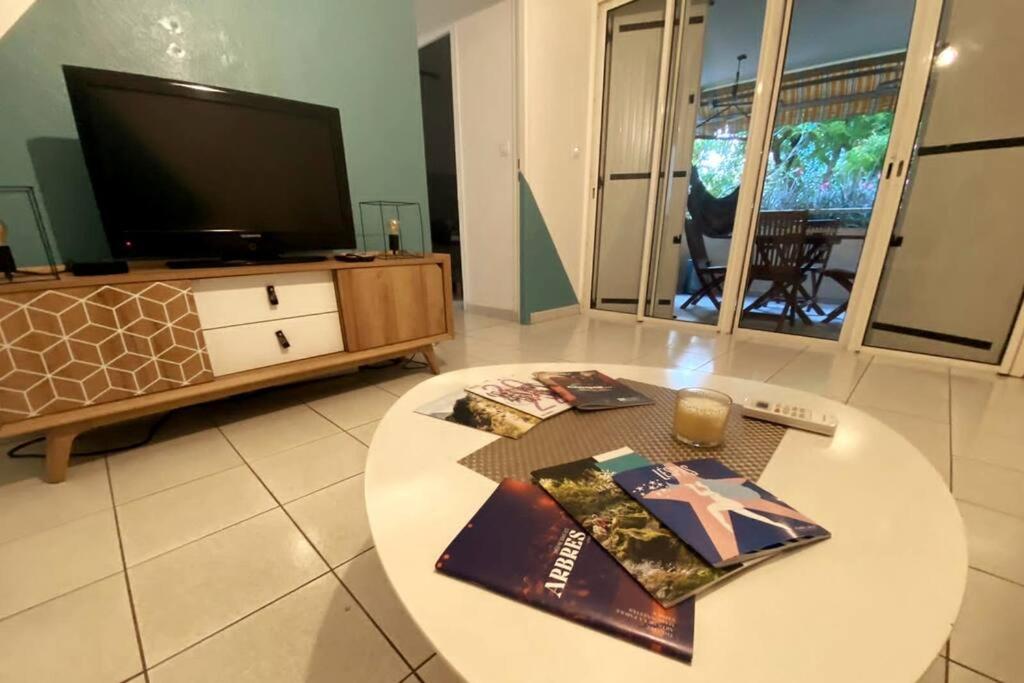 TV a/nebo společenská místnost v ubytování Appart Bénitier 3 étoiles - Ermitage centre à 2 min du Lagon