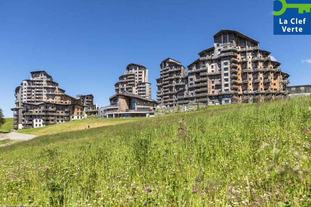 a grassy hill in front of tall buildings at Résidence Pierre & Vacances Premium L'Amara in Avoriaz