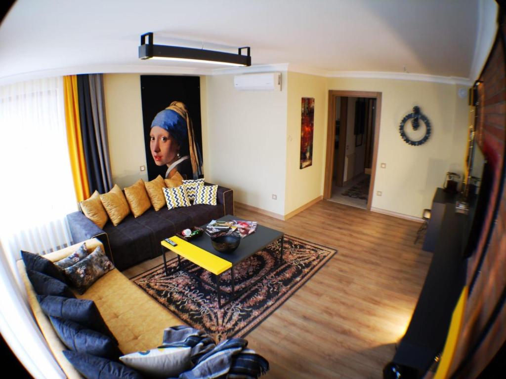 a living room with a couch and a picture of a woman at BUTİK 24 SUİTES in Ankara