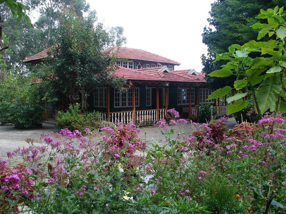 a house with a bunch of flowers in front of it at Lilly's Valley Resort in Kodaikānāl