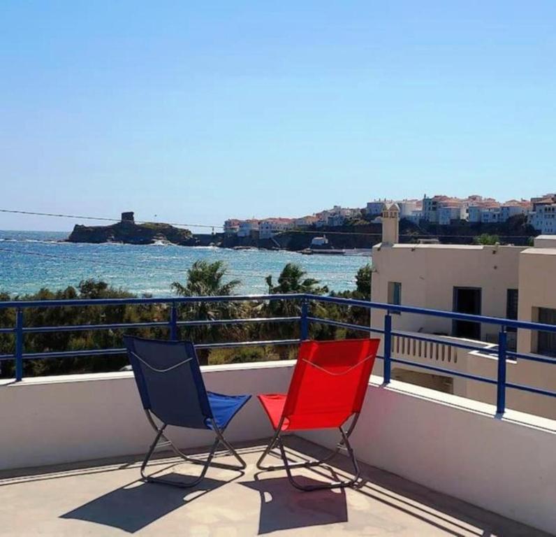 two chairs sitting on a balcony overlooking the water at The house of Nikos and Katerina 2 in Andros