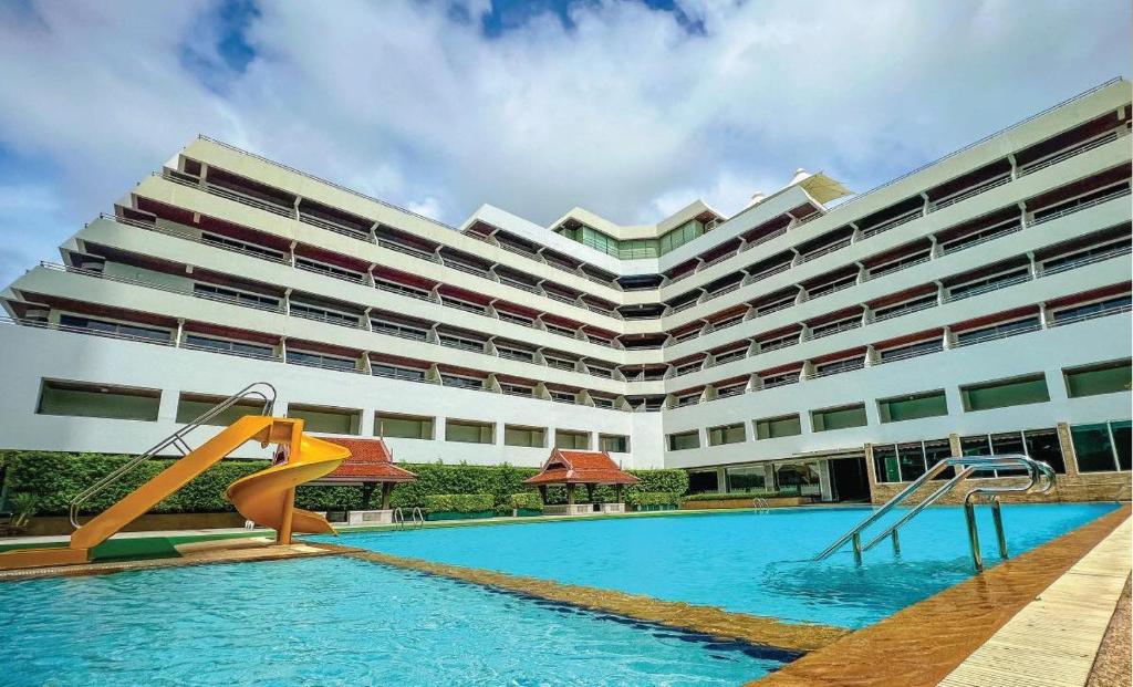 ein Hotel mit einem Pool und einem großen Gebäude in der Unterkunft Patong Resort Hotel - SHA Extra Plus in Patong Beach