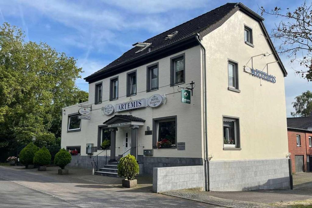 een wit gebouw aan de straatkant bij Hotel Restaurant Artemis in Willich