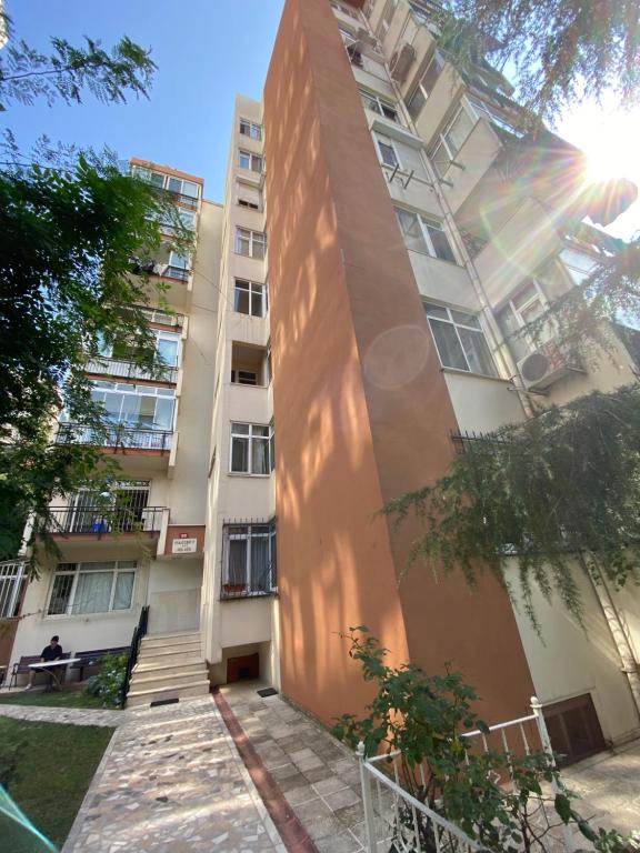a tall apartment building with a person sitting in front of it at Kadıköy Kozyatağında Kiralık Daire in Istanbul