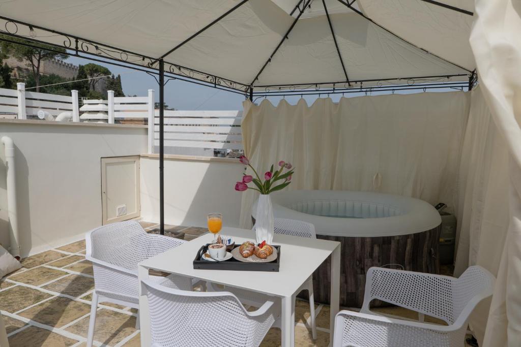een patio met een tafel en stoelen en een bad bij Siramà Suite Deluxe in Oria