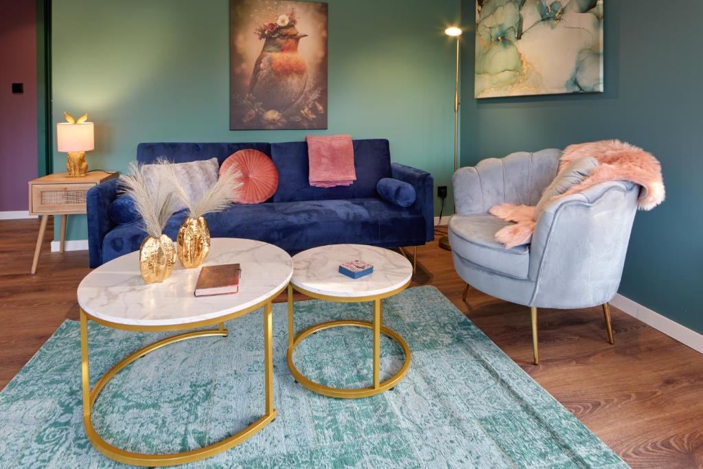 a living room with a blue couch and two tables at Lacuna VITA by Sonnevijver Residences in Lanaken