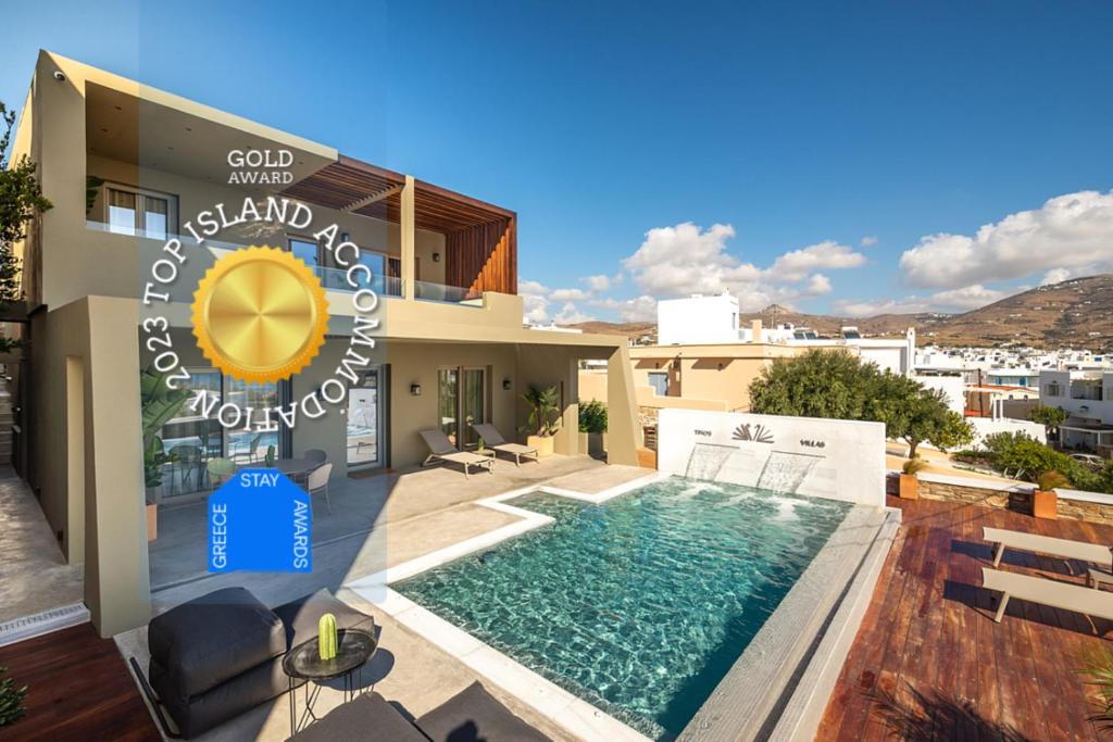 a villa with a swimming pool in front of a house at Coocono Villas in Tinos