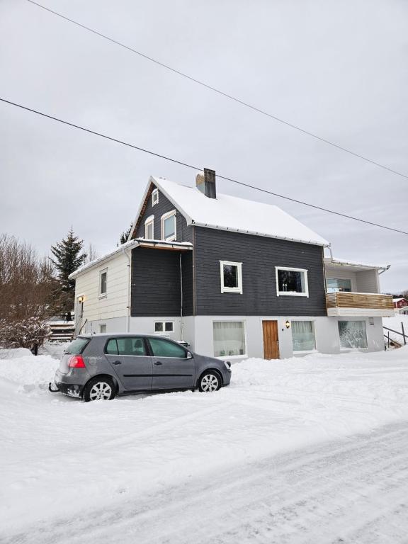 a car parked in the snow in front of a house at House with a wiew in Lenangsøyra