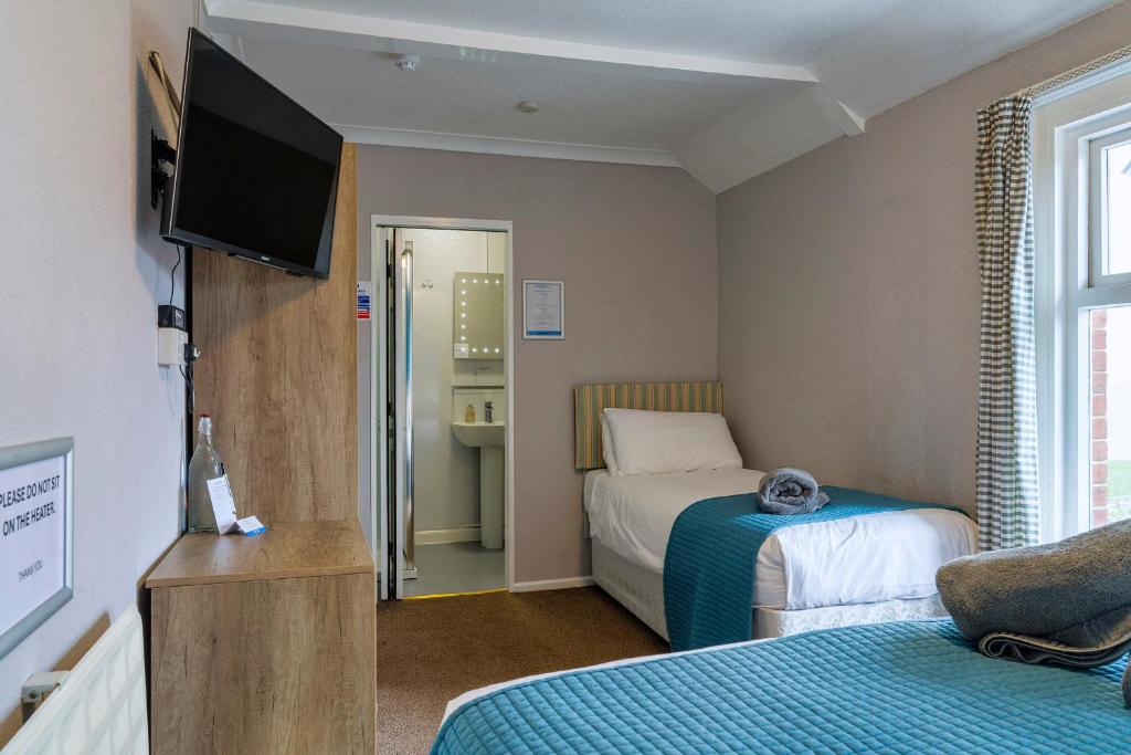 Кровать или кровати в номере Sandcliff Guest House