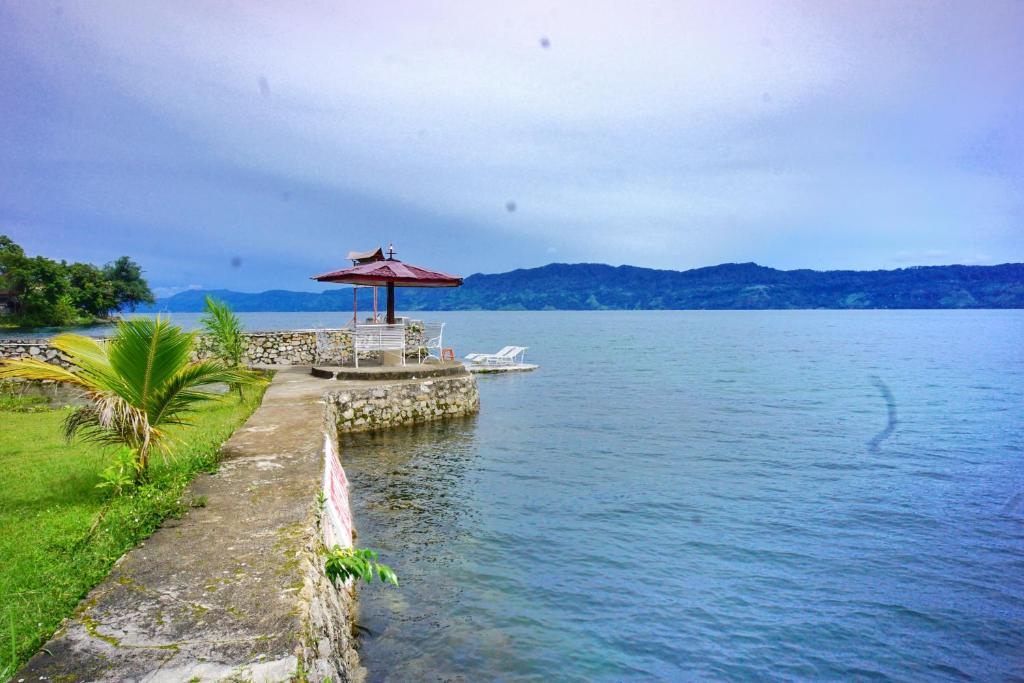 嘟嘟的住宿－潘杜湖濱圖克圖克酒店，湖边带红伞的桌子