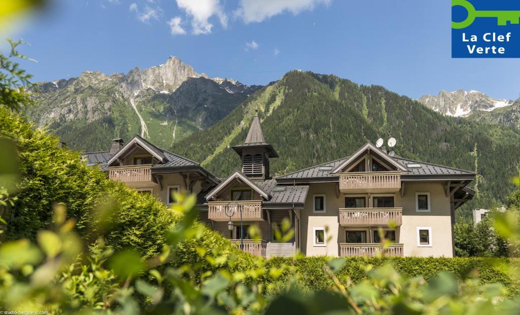ein großes Haus mit Bergen im Hintergrund in der Unterkunft Résidence Pierre & Vacances Premium La Ginabelle in Chamonix-Mont-Blanc