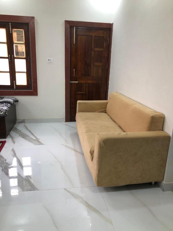 a living room with a couch and a door at Ramaya Home Stay in Varanasi