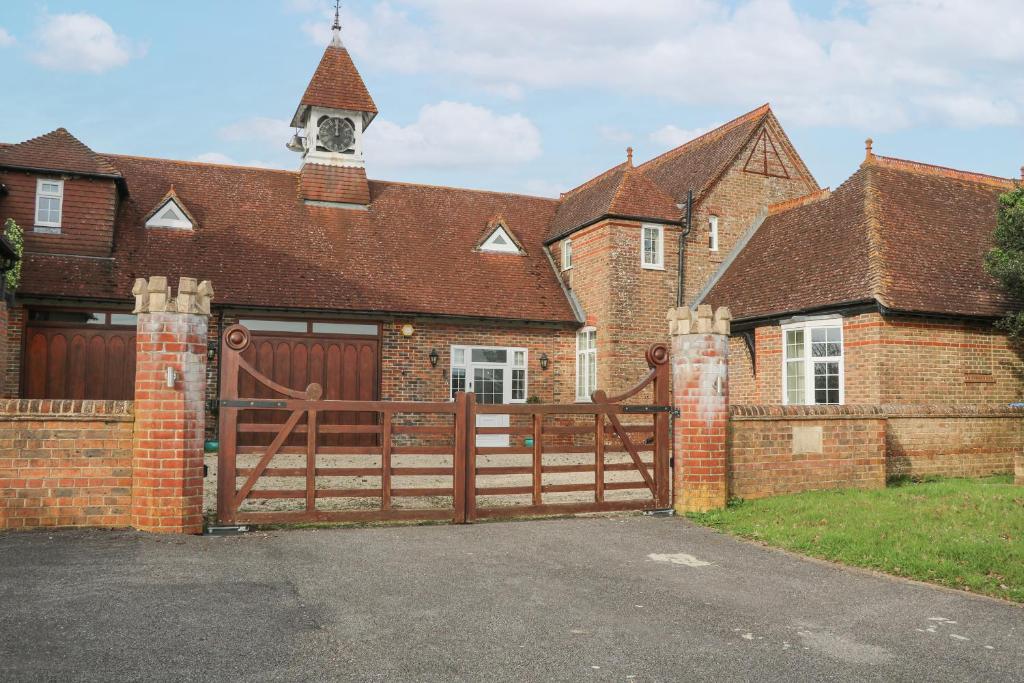 una casa con un cancello in legno e un edificio in mattoni di The Coach House a Haywards Heath