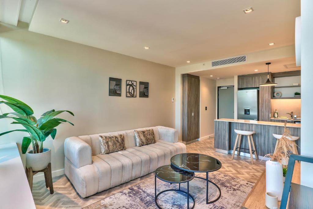 ケープタウンにあるForeshore place 1510 one bedroom apartmentのソファとテーブルのあるリビングルーム