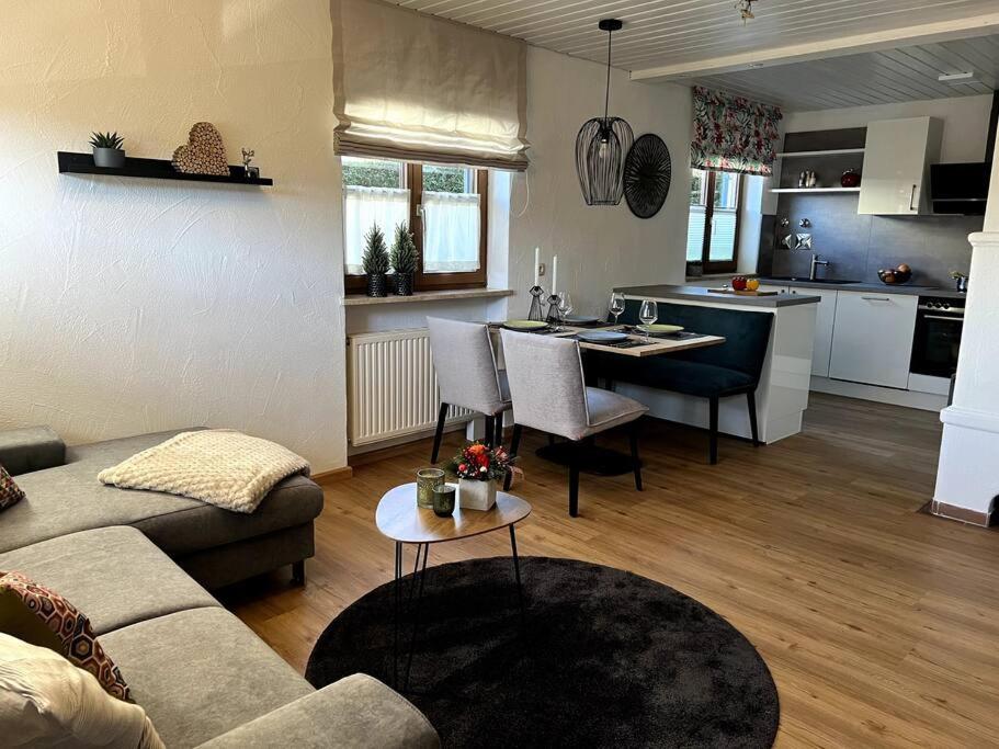 uma sala de estar com um sofá, uma mesa e uma cozinha em Urlaub im Sonnendorf Burgberg em Burgberg