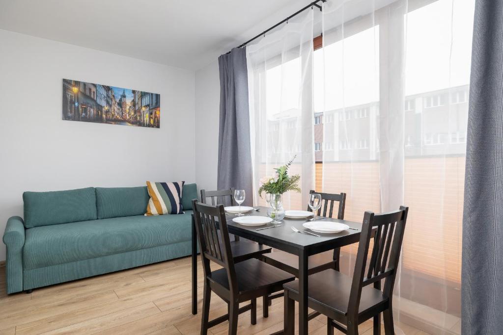 a dining room with a table and chairs and a couch at Luxury Apartment with Balcony & Parking Cracow by Renters Prestige in Krakow