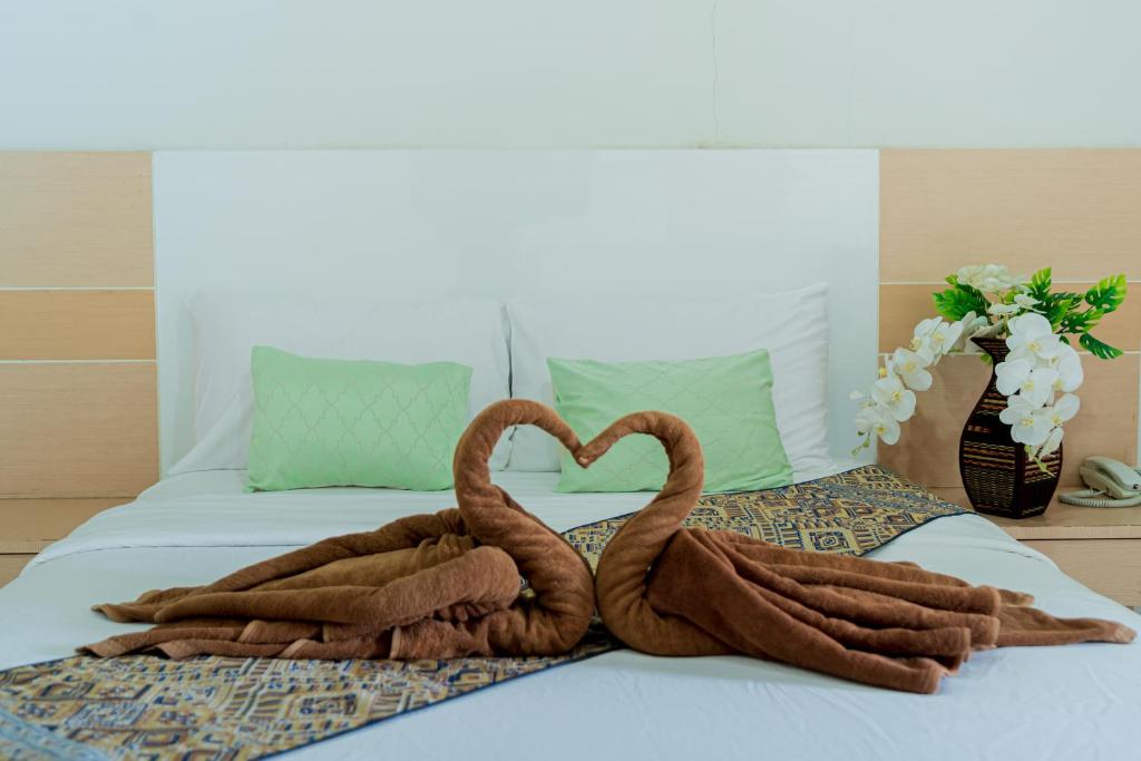 two towel swans making a heart on a bed at The Infinity Suite Chiangrai in Chiang Rai