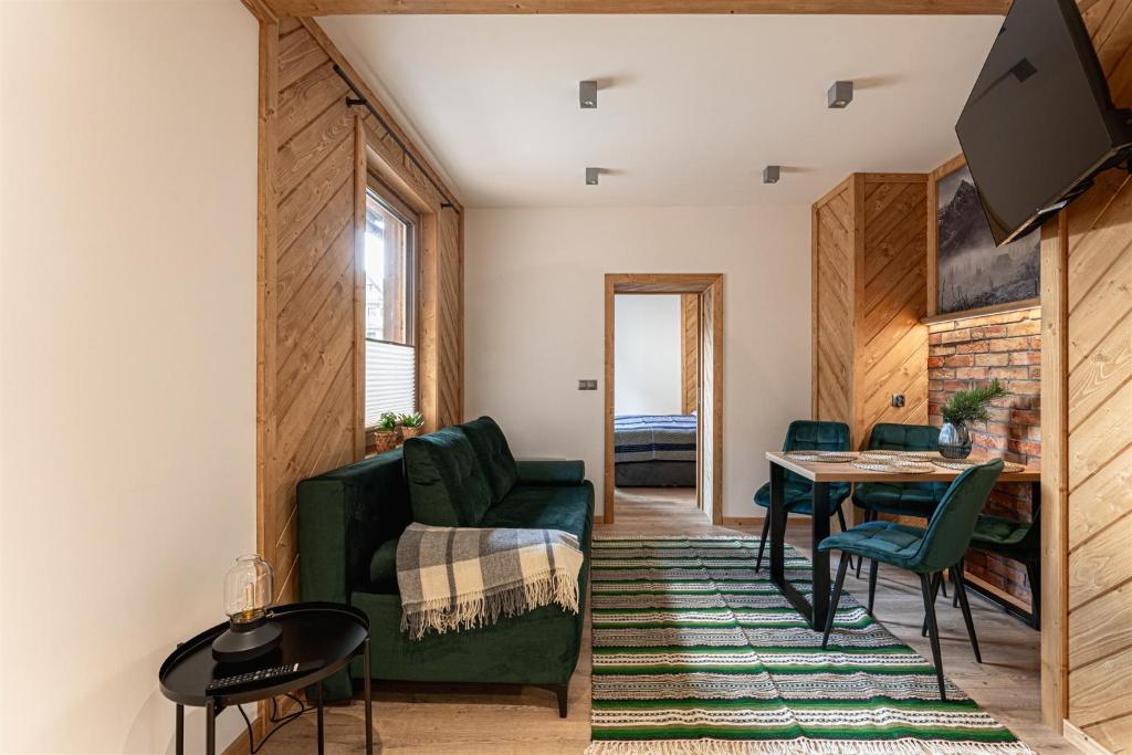 a living room with a green couch and a table at Kosodrzewina in Zakopane