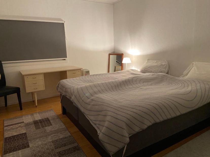 a bedroom with a bed and a desk and a television at Nice place near the sea and forest in Larvik