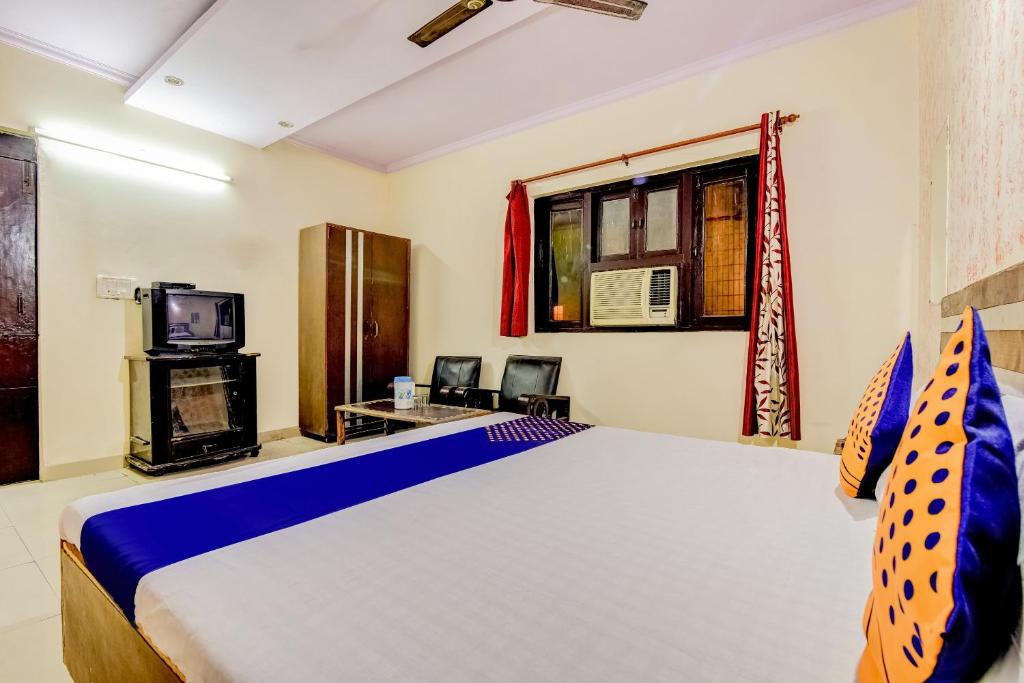 een slaapkamer met een groot bed en een televisie bij Flagship Hotel Swagat Palace in New Delhi