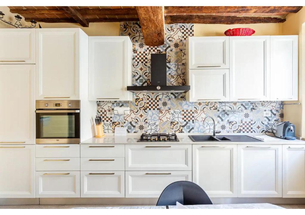 uma cozinha branca com armários brancos e um micro-ondas em 106 Lodge em Siena