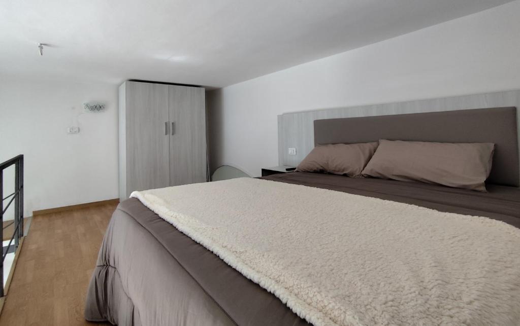 1 dormitorio con 1 cama grande en una habitación blanca en Casa lago di lesina, en Lesina