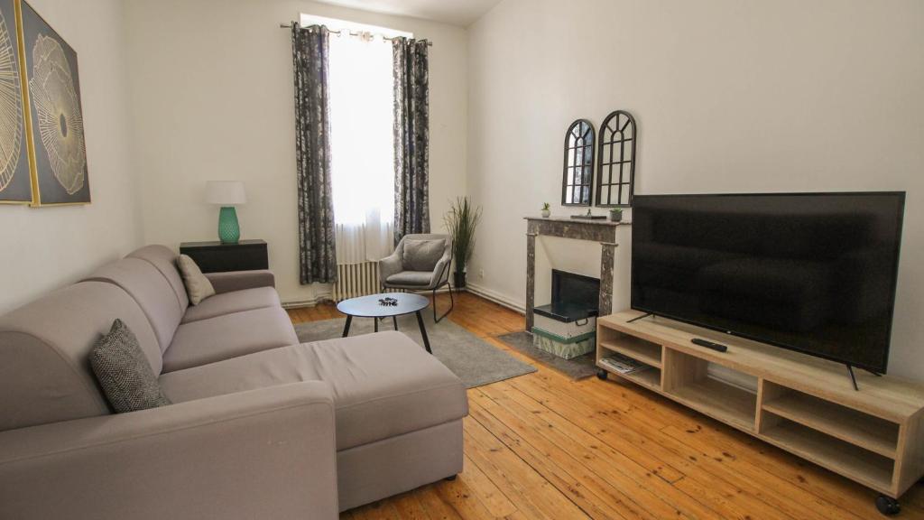 a living room with a couch and a flat screen tv at Residence Pasteur Angouleme in Angoulême