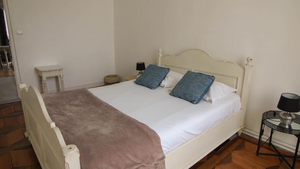 a bedroom with a white bed with blue pillows at Residence Pasteur Angouleme in Angoulême